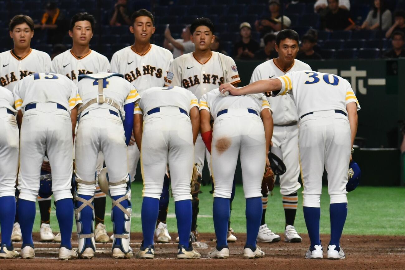 石崎監督はウィニングボールを握りしめた左手を三ツ井主将の背中に回した