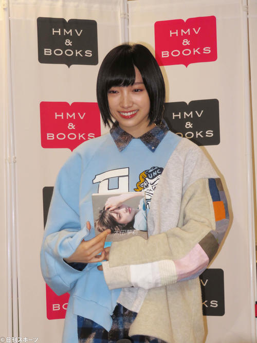 初のフォトエッセーを持って笑顔を見せる太田夢莉（撮影・横山慧）