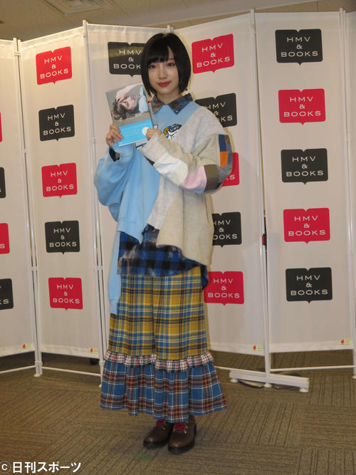 初のフォトエッセーを持って笑顔を見せる太田夢莉（撮影・横山慧）