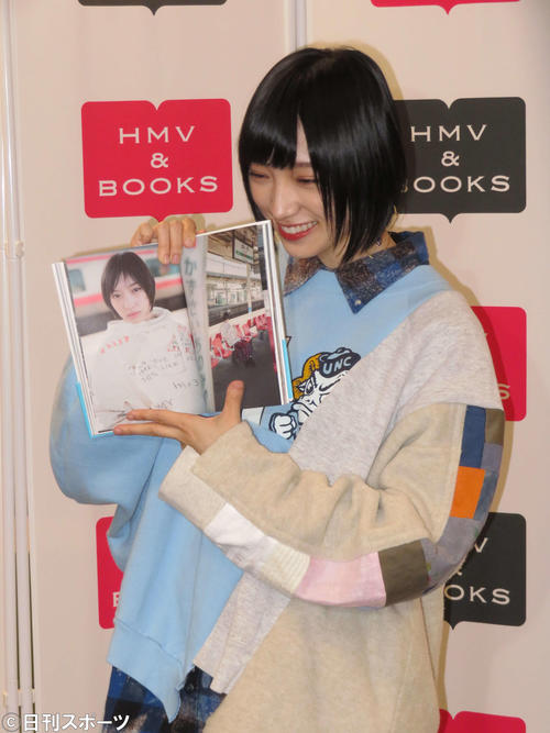 初のフォトエッセーを持って笑顔を見せる太田夢莉（撮影・横山慧）