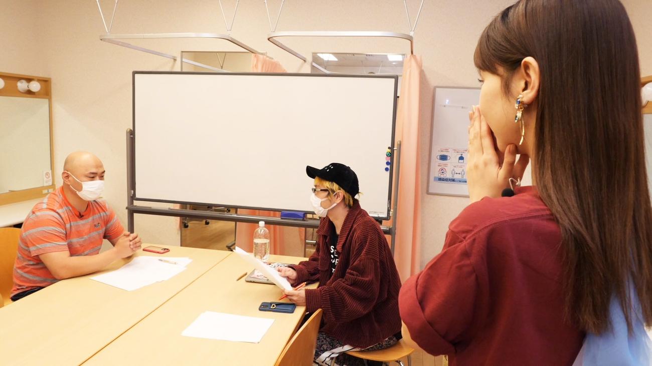 豆柴の大群アドバイザーのクロちゃん（左）とプロデューサー渡辺淳之介氏（右）が歌詞について話し合う姿に驚く柏木由紀