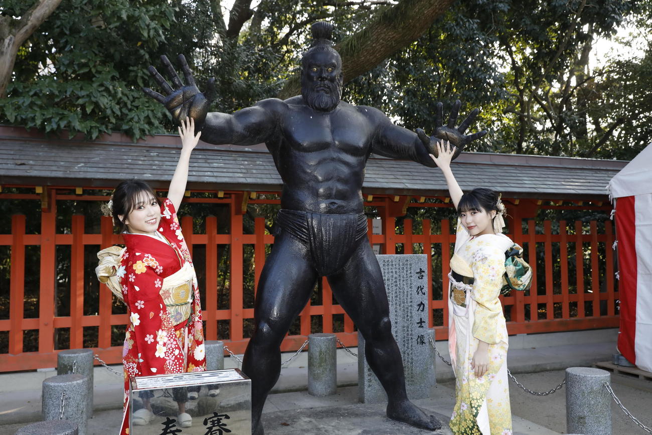 成人式を行い古代力士像とポーズをとるHKT48矢吹奈子（左）と田中美久（C）Mercury