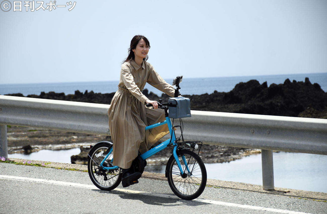 海をバックにサイクリングを楽しむ西潟茉莉奈（撮影・大友陽平）