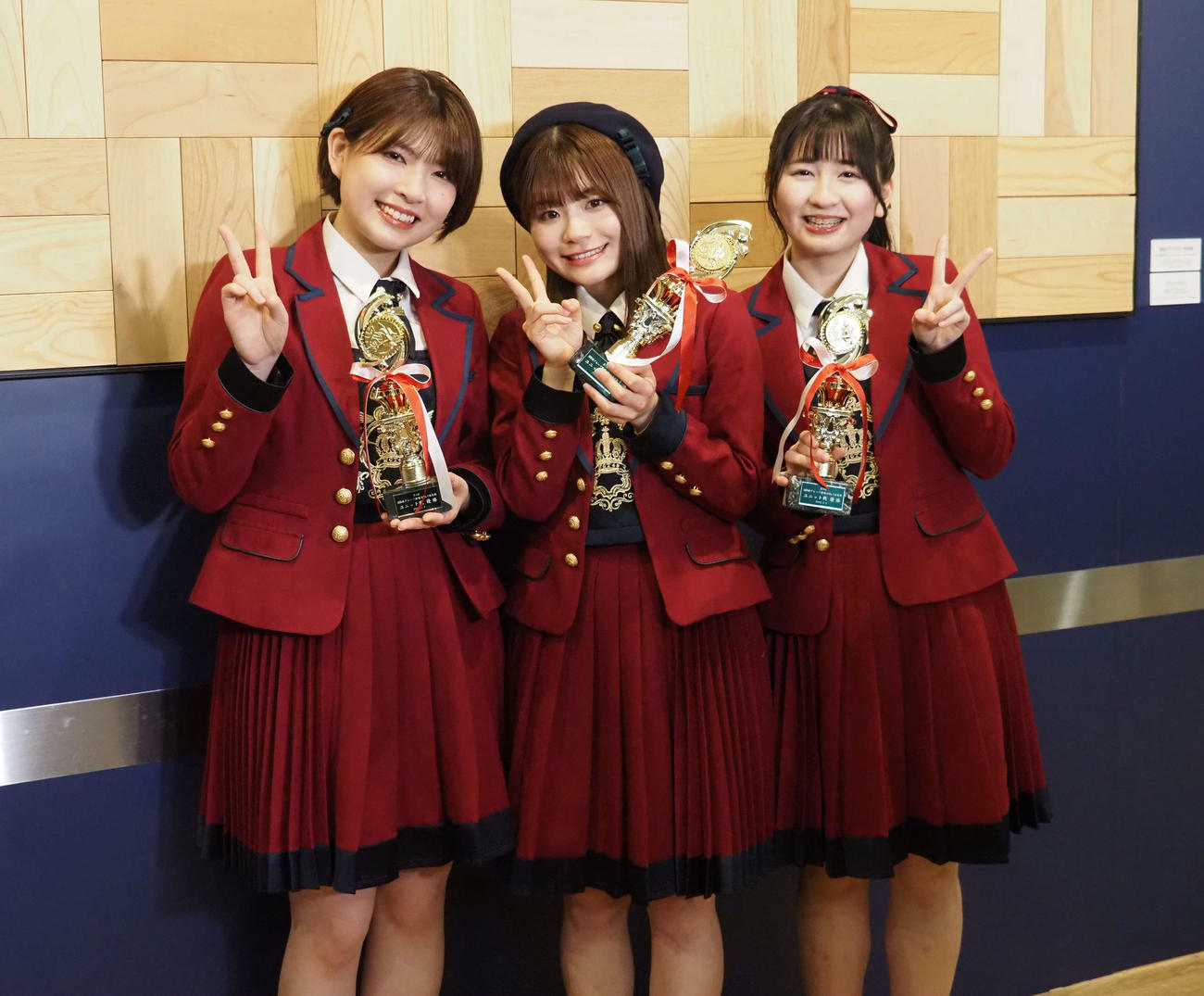 トロフィーを手にピースサインを作るNGT48メンバー。左から三村妃乃、清司麗菜、新井りりの（撮影・遠藤尚子）