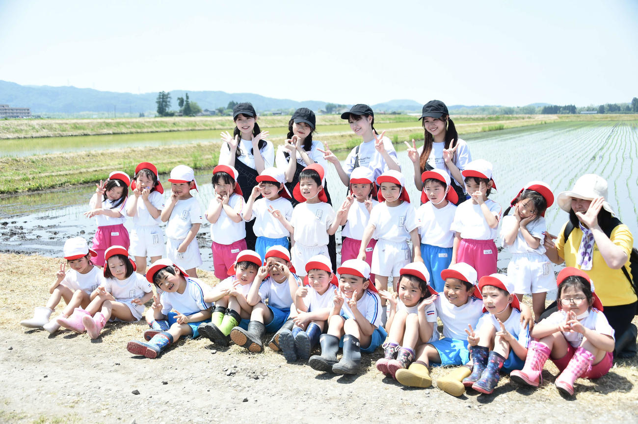 園児と記念撮影をするNGT48の、左から小越春花、中井りか、西潟茉莉奈、真下華穂