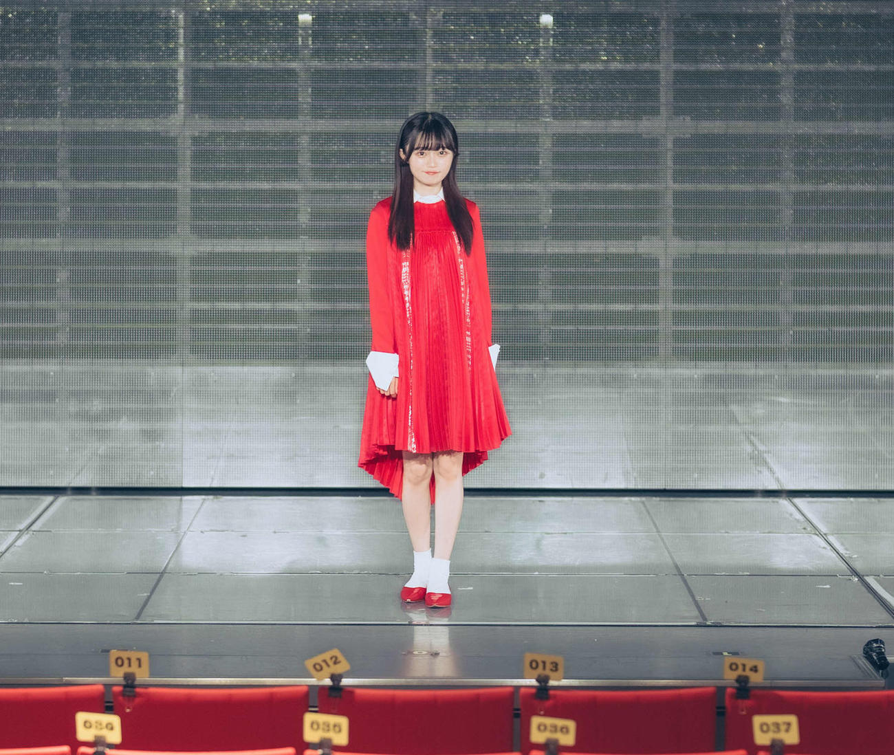 卒業公演を前にデビュー曲の「青春時計」の衣装で劇場ステージに立つ中井