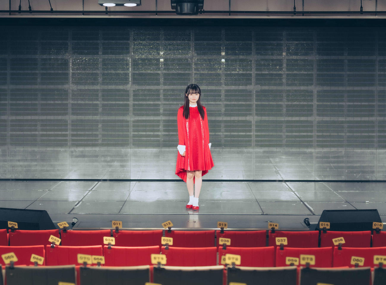 卒業公演を前にデビュー曲の「青春時計」の衣装で劇場ステージに立つ中井