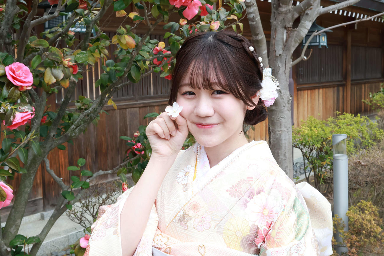 桜の花びらを手に笑顔の水津菜月　（撮影・大塚七海）