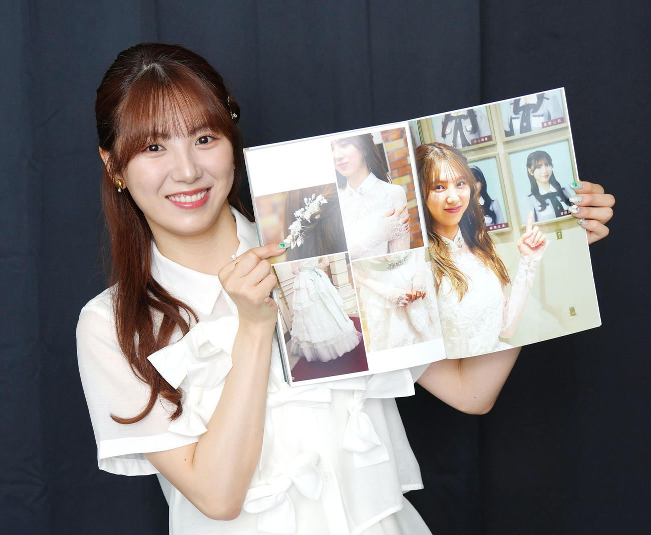 写真集のお気に入りのカットを見せるSKE48菅原茉椰（撮影・足立雅史）