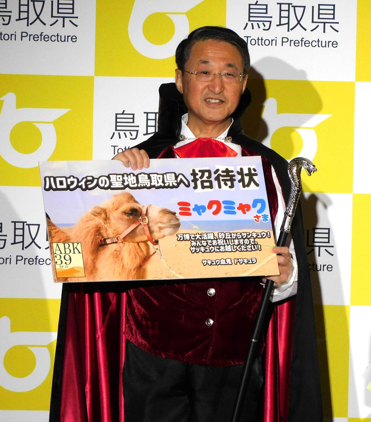 「鳥取ハロウィン楽しみ大使」就任発表会に出席し,ミャクミャクへの招待状を手にする鳥取県の平井伸治知事（撮影・寺本吏輝）