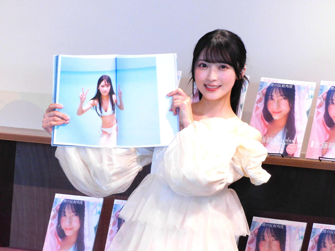 ファースト写真集「天使の反射角度」発売記念会見を行い、お気に入りカットを見せるAKB48佐藤綺星（撮影・寺本吏輝）