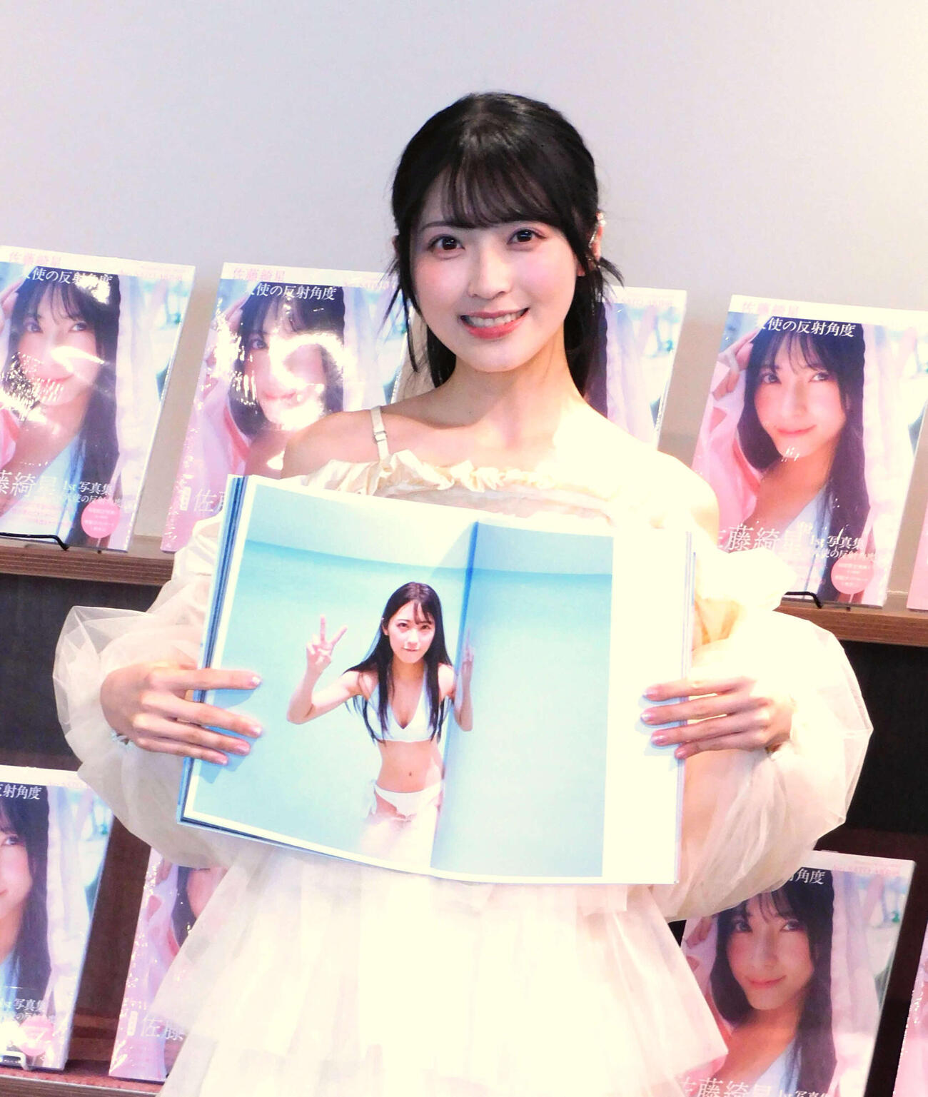 ファースト写真集「天使の反射角度」発売記念会見を行い、お気に入りカットを見せるAKB48佐藤綺星（撮影・寺本吏輝）