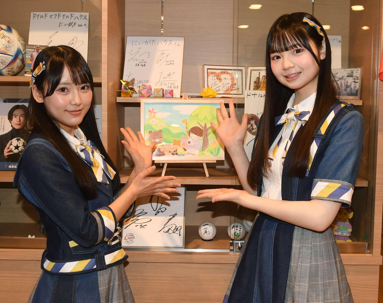 AKB48丸山ひなた（左）の自作イラストを大賀彩姫と一緒に飾る