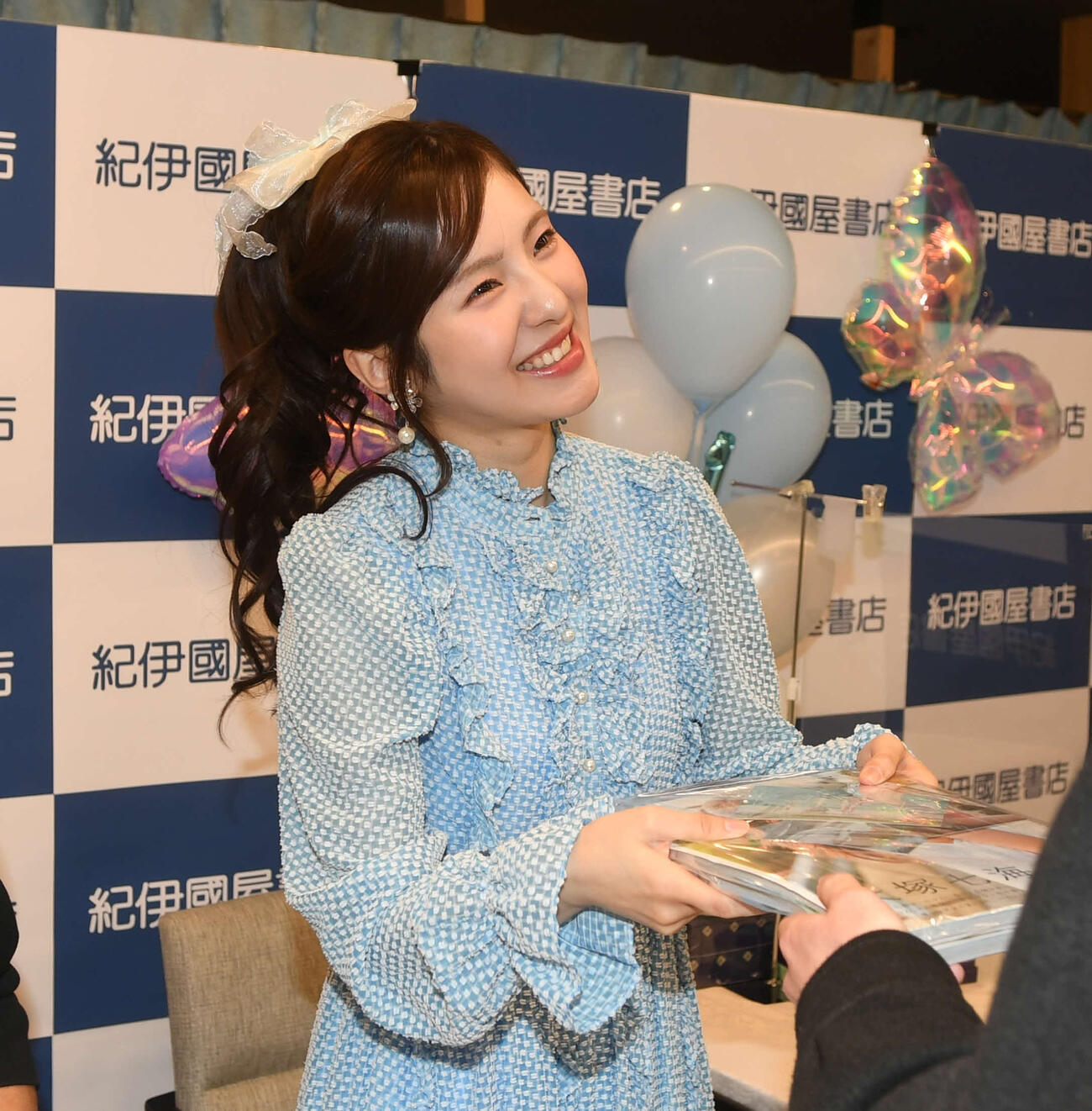 新潟でのイベントで写真集をファンに手渡す大塚七海