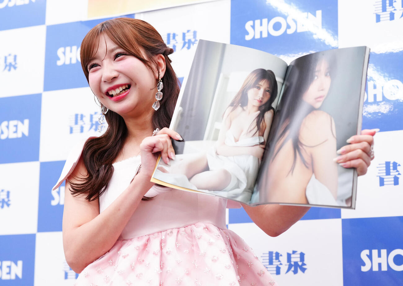 ファースト写真集「ニドメボレ」発売記念記者会見で、お気に入りのページを手に笑顔のSKE48太田彩夏（撮影・鈴木みどり）
