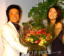 来日会見でイ・ボムス（左）に花束を渡すゲストの村川絵梨