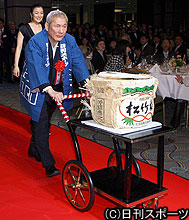 レッドカーペットの上を鏡開きの酒だるを押しながら歩く北野武監督と鈴木京香