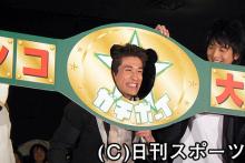初日舞台あいさつで、佐藤隆太はチャンピオンベルトから顔を出しておどけた