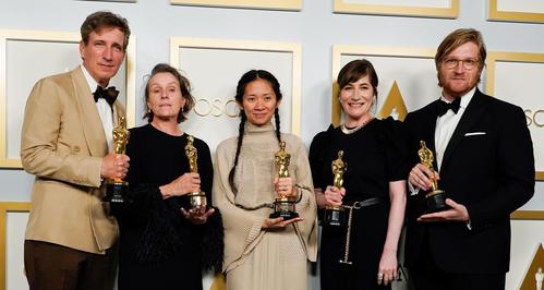 作品賞と監督賞を受賞した「ノマドランド」のクロエ・ジャオ監督（中央）ら（ロイター）