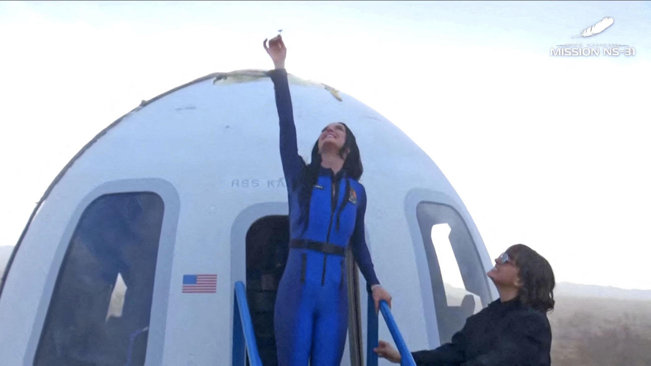 宇宙飛行を終え、無事着陸し宇宙船「ニューシェパード」から出た米歌手ケイティ・ペリー（左）＝14日、米南部テキサス州（ブルーオリジン提供、ロイター＝共同）