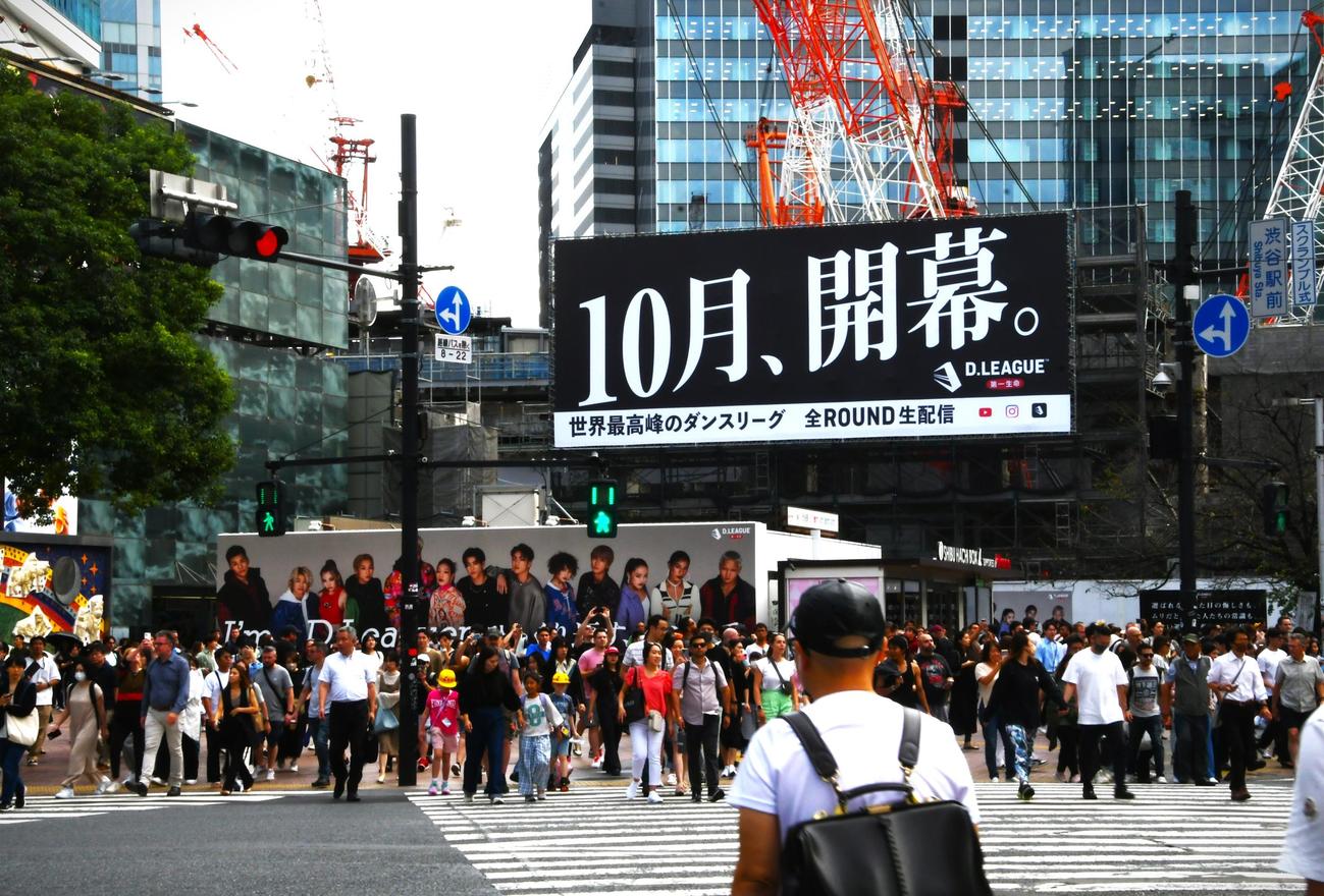 渋谷駅のハチ公前広場に掲出されD.LEAGUEの看板「10月開幕、I'm a D.Leaguerひっくり返せ、ダンスで。」。スクランブル交差点を渡ながら一望できる（撮影・久我悟）