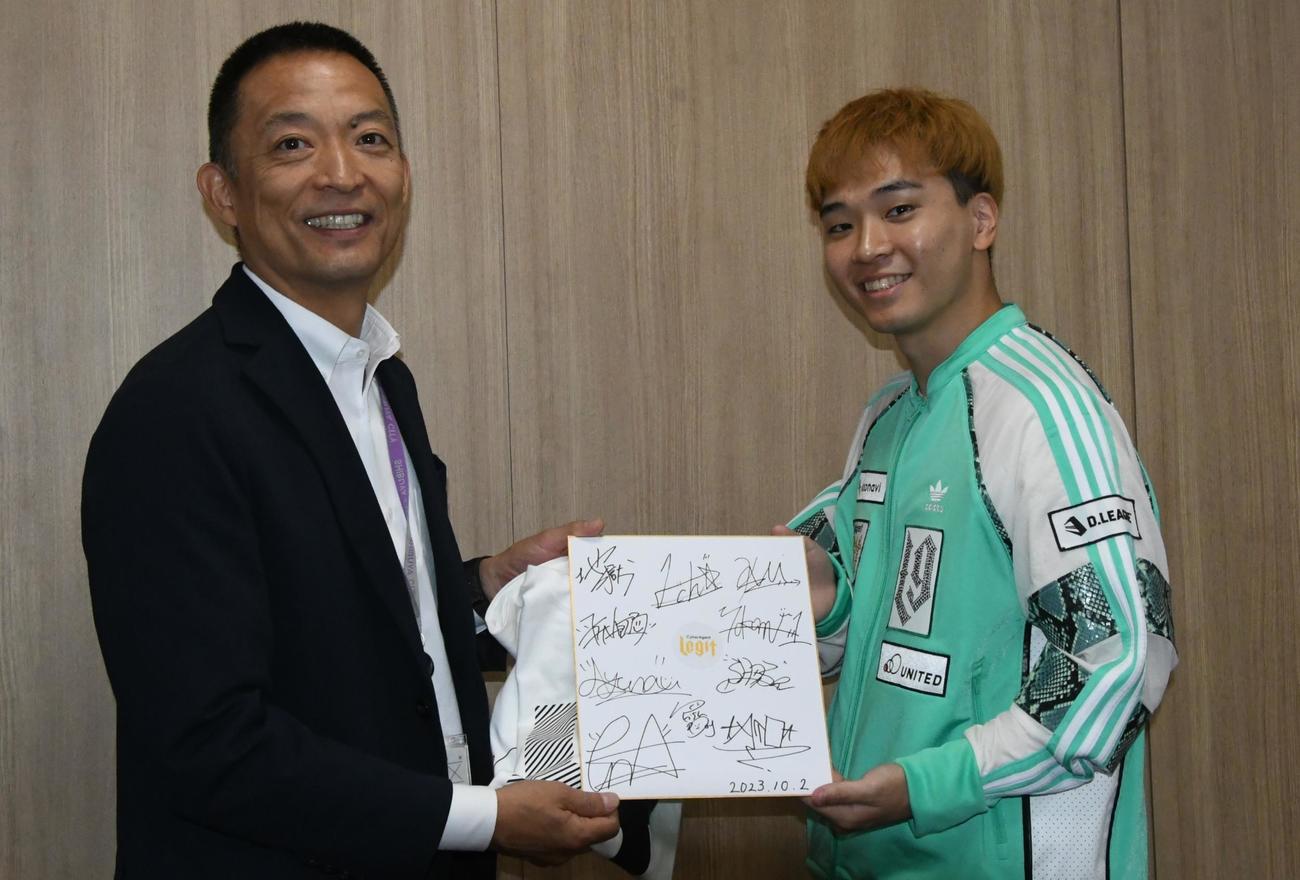 ATO（右）からLegitのサインを受け取った長谷部区長