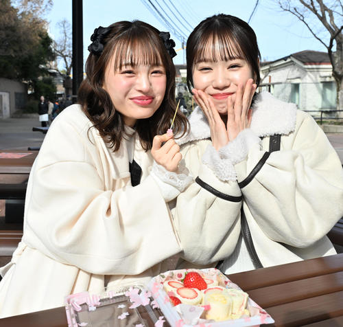 NMB48新澤菜央（左）からサンドイッチを食べさせてもらい笑顔を見せる水田詩織（撮影・石井愛子）