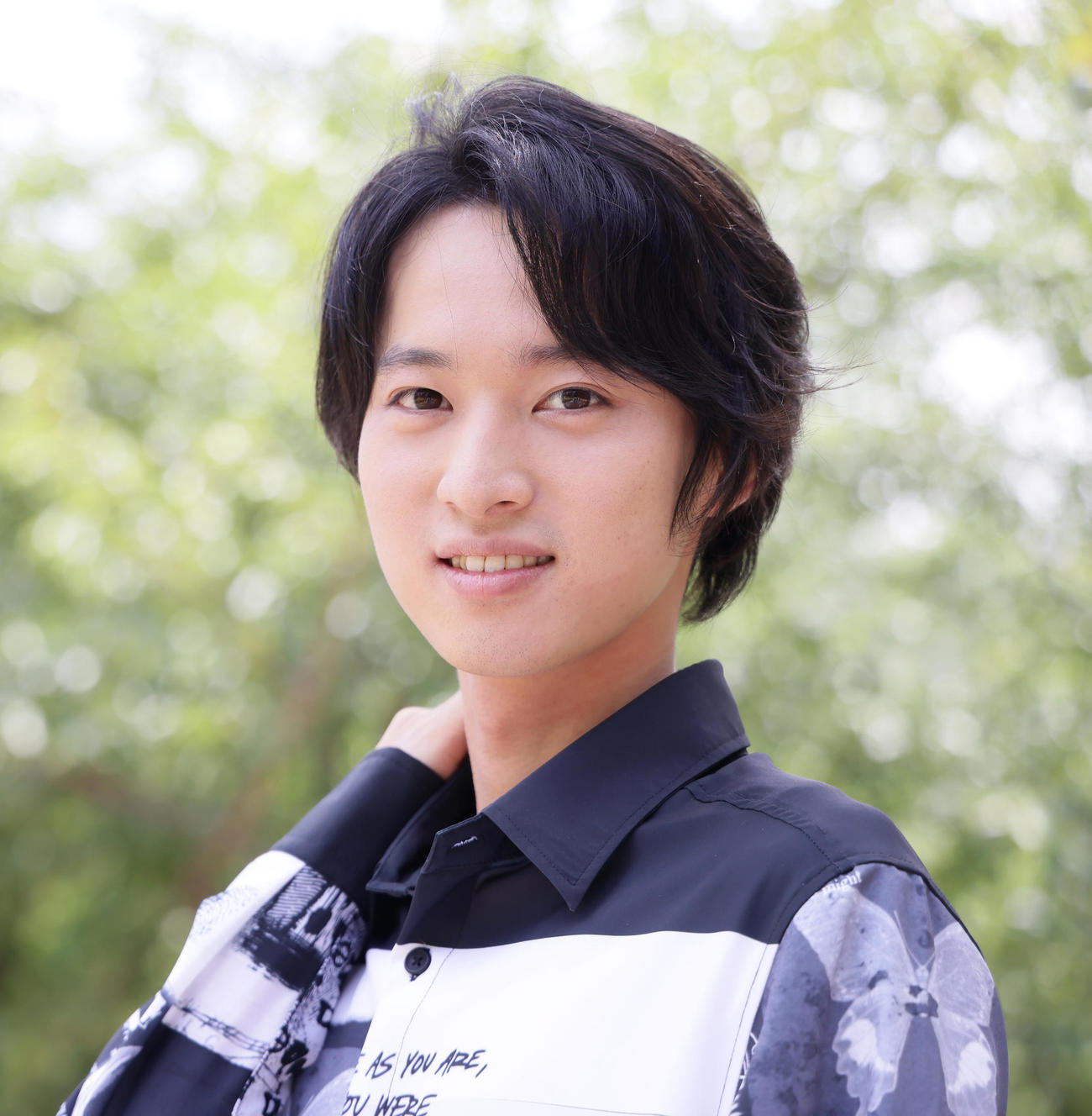 きらめく木々を背に笑顔を見せる青山新（撮影・足立雅史）