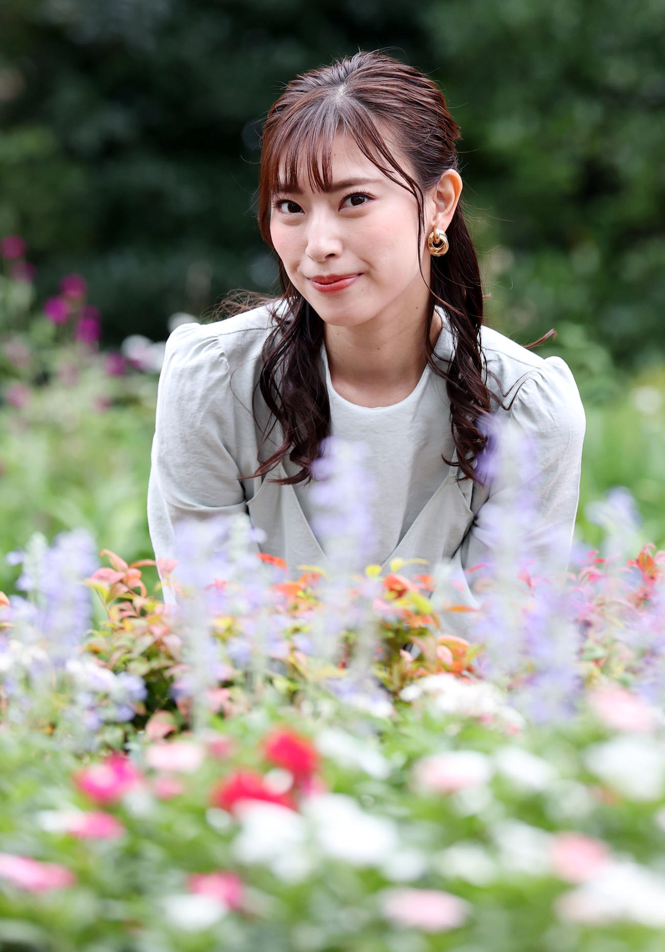 秋の花々が咲く中、優しい笑顔を見せる藤井香愛（撮影・狩俣裕三）