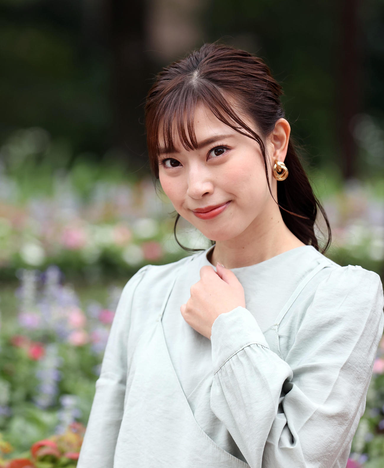 秋の花々を背に優しい笑顔を見せる藤井香愛（撮影・狩俣裕三）
