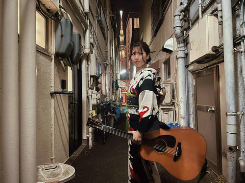 小林幸子から贈られた着物を着て東京・浅草の路地裏に立つ流しのおかゆ