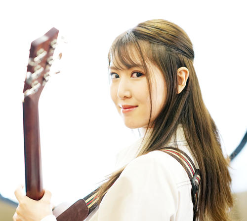 ギターを抱えポーズを決めるおかゆ(撮影・横山健太)