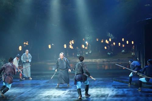 舞台奥が開く能登演劇堂で舞台「いのちぼうにふろう物語」主演の仲代達矢（中央）は立ち回りを見せる（2022年9月撮影）