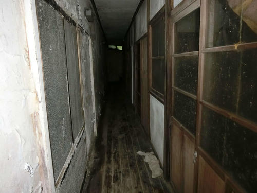 1階の廊下は暗く、床があちこちへこんでおり、崩落するかもしれないという“恐怖”とたたかいつつ温泉へ