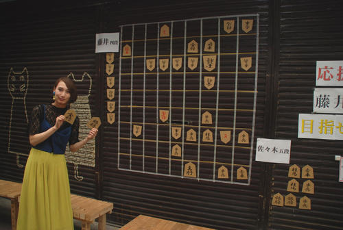 愛知県瀬戸市の「せと銀座通り商店街」では店舗のシャッターにある大きな将棋盤と飯島加奈さん（撮影・松浦隆司）