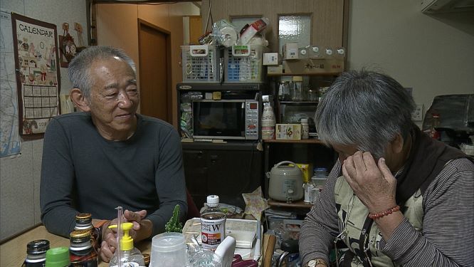 「震災障害者」の自宅を訪問する牧秀一さん（左）（MBSテレビ提供）