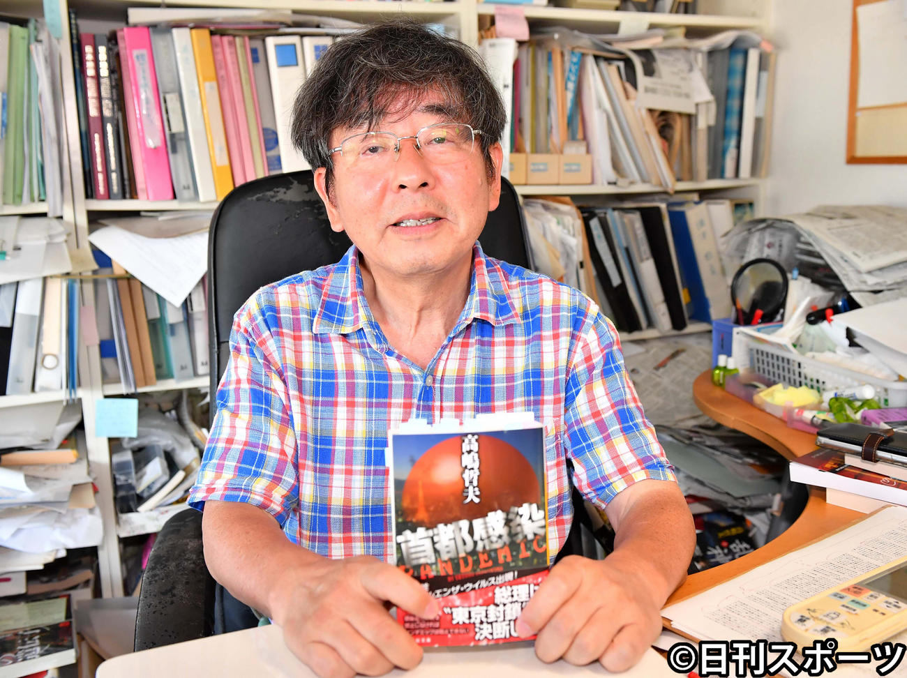 著書の「首都感染」を手にする高嶋哲夫氏（2020年8月12日撮影）