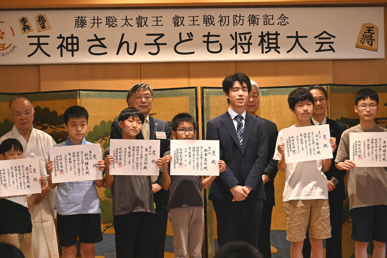 北野天満宮で開催された「天神さん子ども将棋大会」で入賞した子どもたちと記念撮影する藤井聡太5冠（右から3人目）（撮影・松浦隆司）