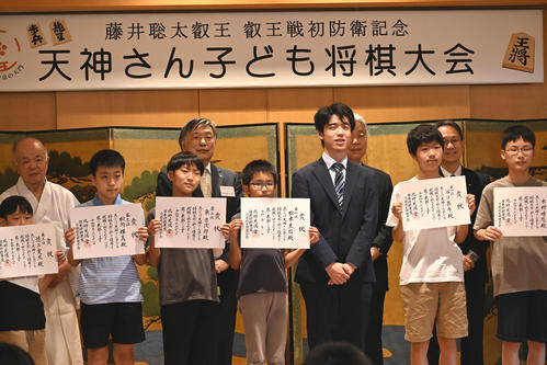 北野天満宮で開催された「天神さん子ども将棋大会」で入賞した子どもたちと記念撮影する藤井聡太5冠(右から3人目)(撮影・松浦隆司)