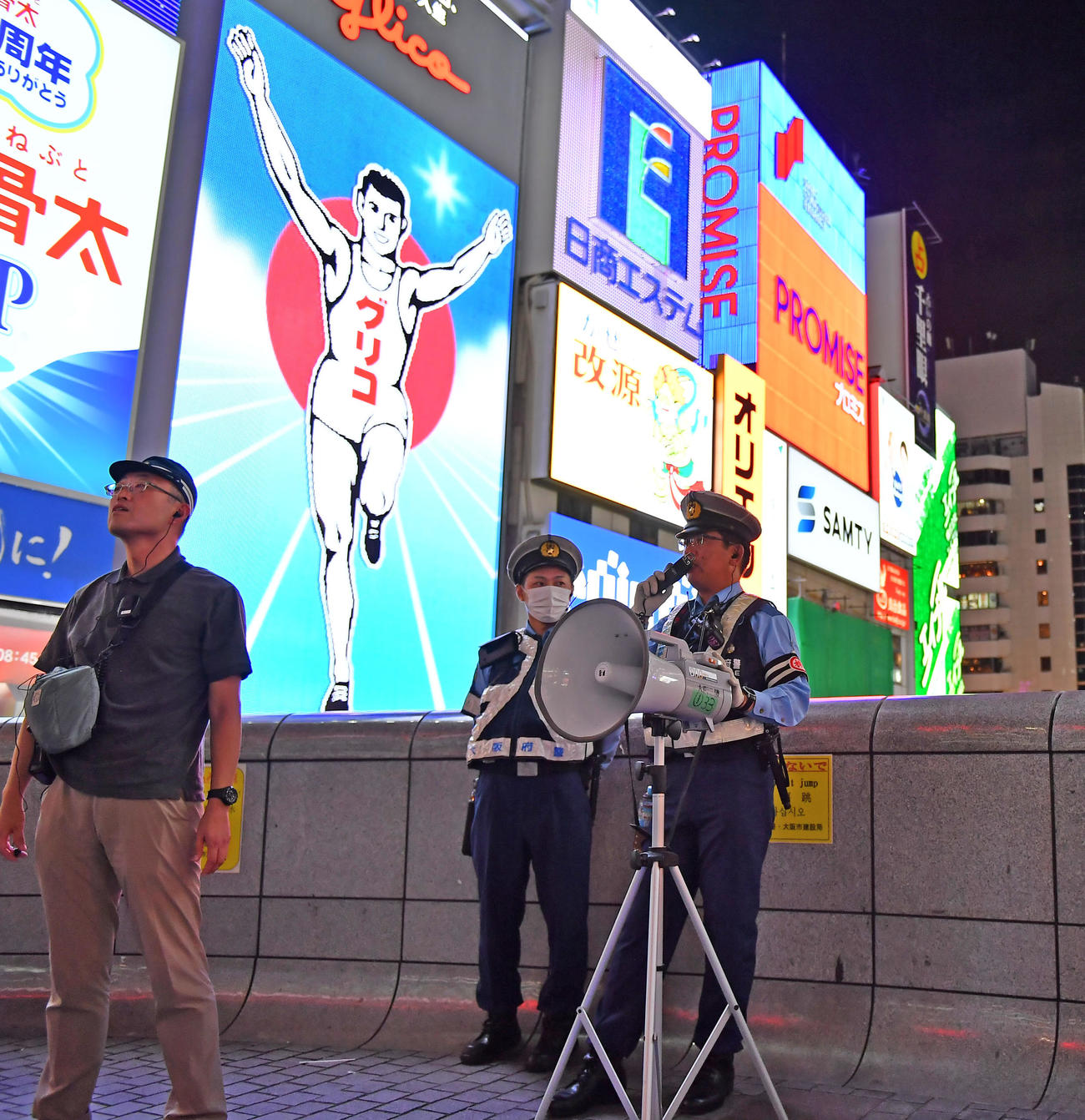 道頓堀の戎橋で、歩行者に立ち止まらないよう注意を促す警察官（撮影・清水貴仁）