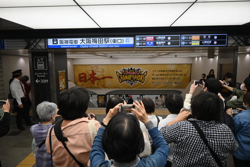阪神日本一から一夜明け、阪神電車「大阪梅田駅」の東改札口の階段の上にはスマートフォンを掲げた人で込み合った（撮影・松浦隆司）