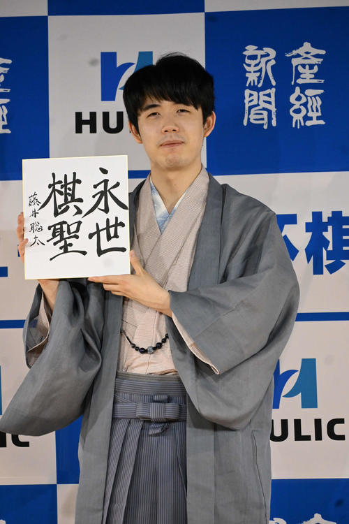 自筆の「永世棋聖」の色紙を持つ藤井聡太棋聖（撮影・松浦隆司）