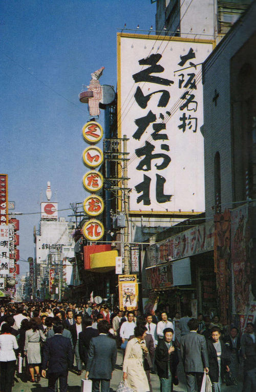 写真<1>、1974年(昭49)当時の食堂「くいだおれ」のネオンサイン、「大阪名物 くいだおれ」の看板の横に先代の「太郎看板」