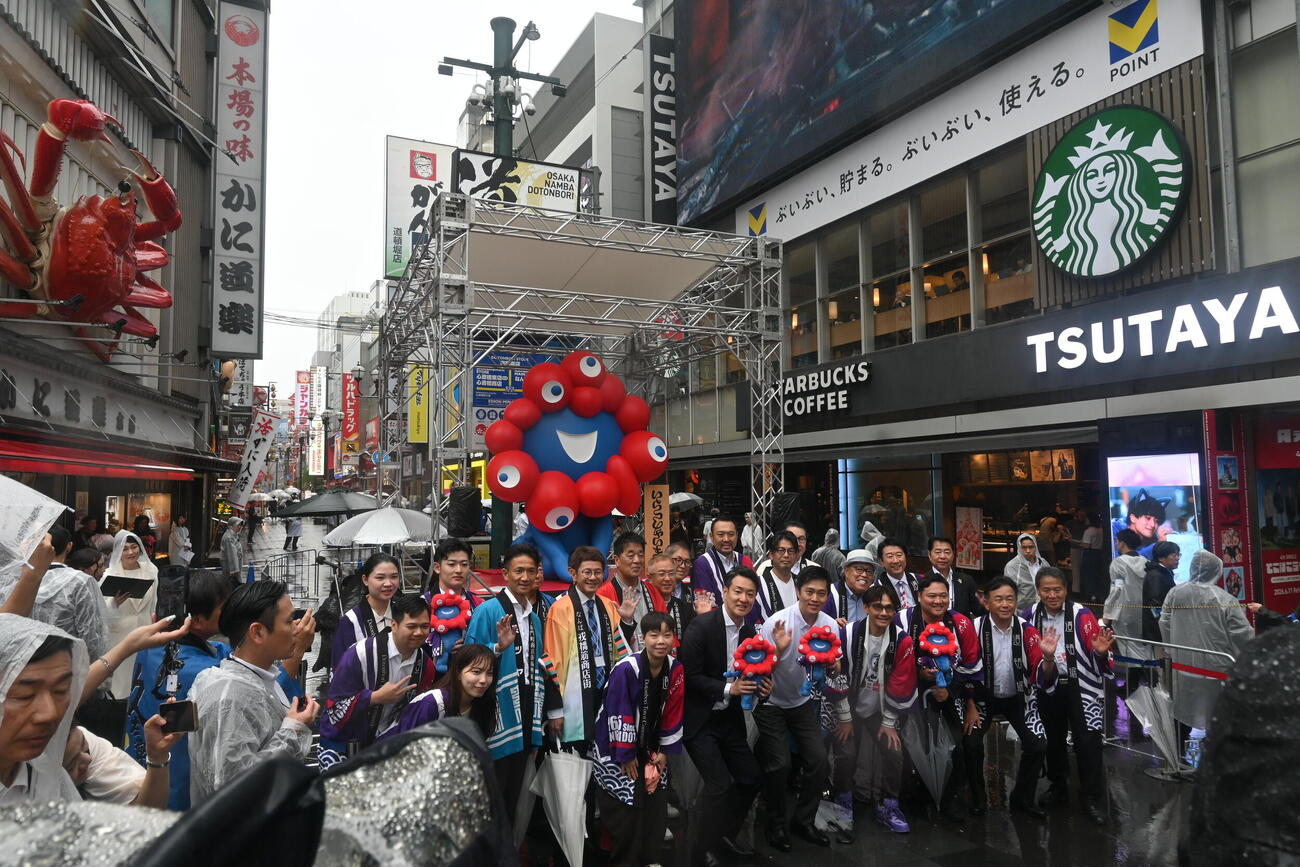 大阪・ミナミの「かに道楽道頓堀本店」前に設置された大阪・関西万博の公式キャラクター「ミャクミャク」のモニュメント「いらっしゃい」（撮影・松浦隆司）