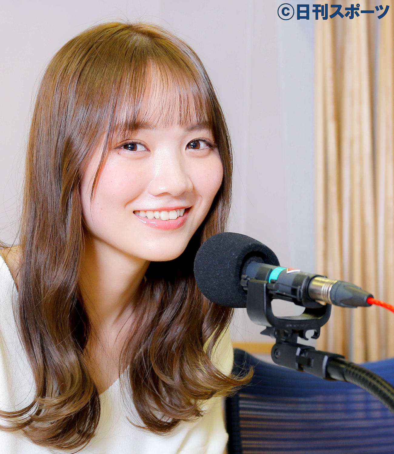 ラジオパーソナリティーを務める乃木坂46田村真佑はマイクの前でウキウキした表情を浮かべる（撮影・河田真司）