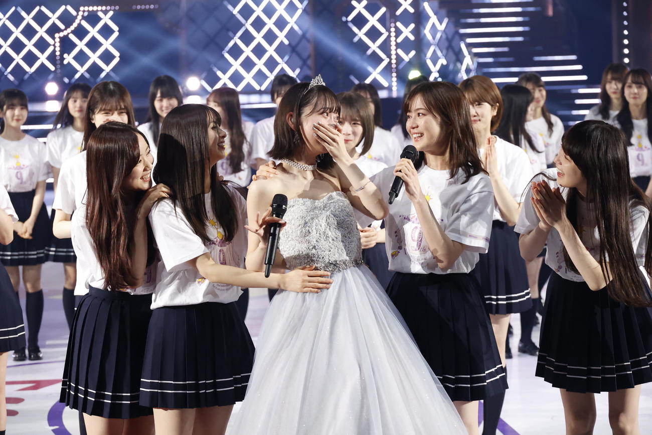先輩の1期生がサプライズ登場し、驚き涙する堀未央奈（前列左から3人目）