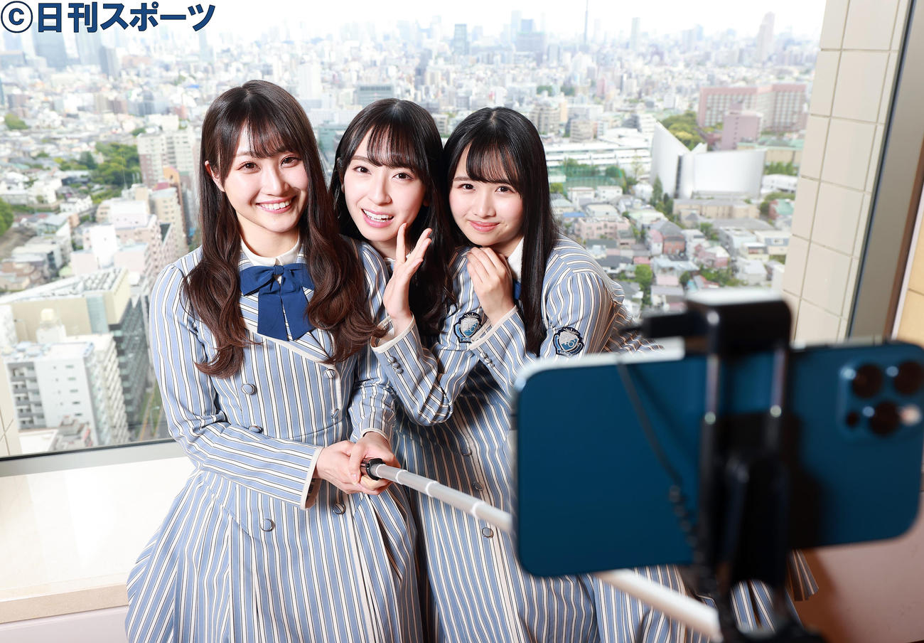 自撮り棒で笑顔で写る日向坂46の、左から潮紗理菜、金村美玖、上村ひなの（撮影・浅見桂子）