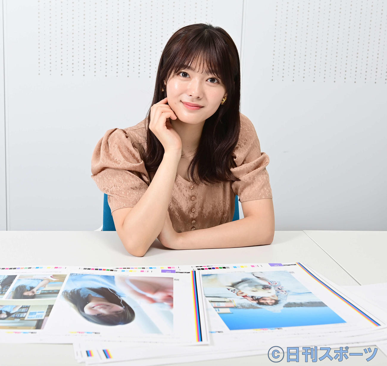 1st写真集「一歩目」で掲載される写真の見本を前に笑顔を見せる櫻坂46田村保乃（撮影・小沢裕）
