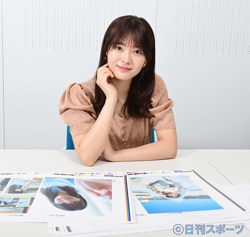 1st写真集「一歩目」で掲載される写真の見本を前に笑顔を見せる櫻坂46田村保乃（撮影・小沢裕）
