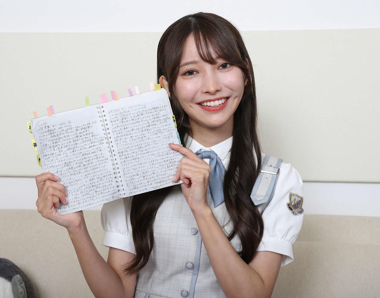選手の魅力や個性、プレー内容がびっしりと書き込まれた「黒見ノート」を手に笑顔を見せる乃木坂46黒見明香（撮影・丹羽敏通）